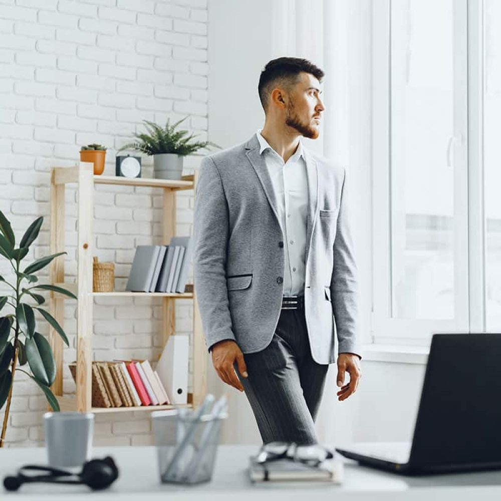 young-businessman-standing-by-the-window-at-his-of-2023-11-27-05-35-20-utc-copy.jpg